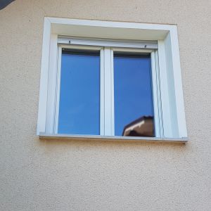 Hiša z belimi PVC okni in nadokenskimi roletami